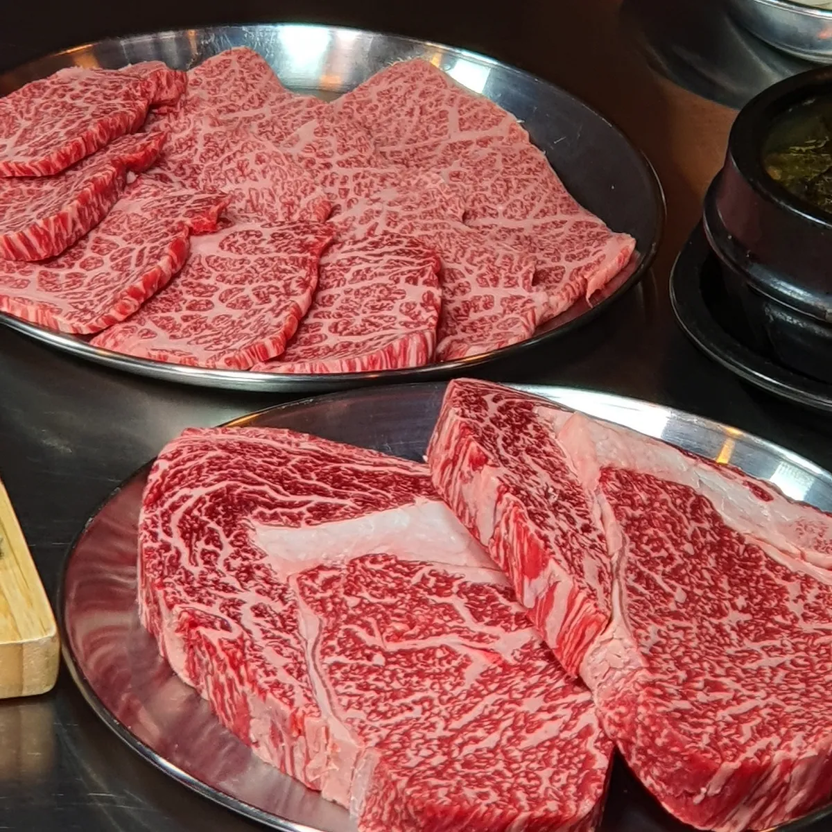 83BeeF 東莱本店 — 霜降りの韓牛を盛った二つの皿