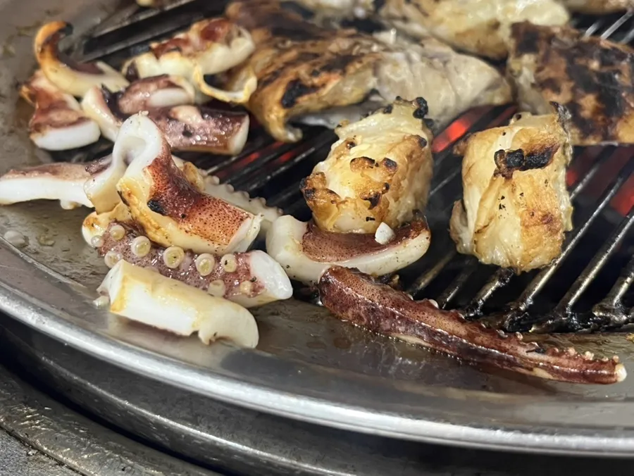 88センソンクイ — 網の上で焼けるイカと白身魚