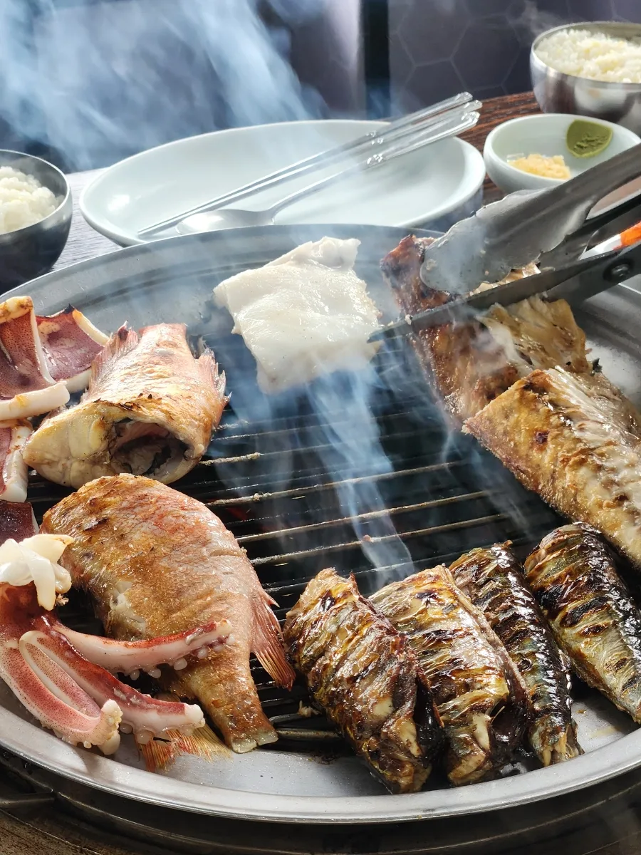 魚を焼く網から立ち上る煙