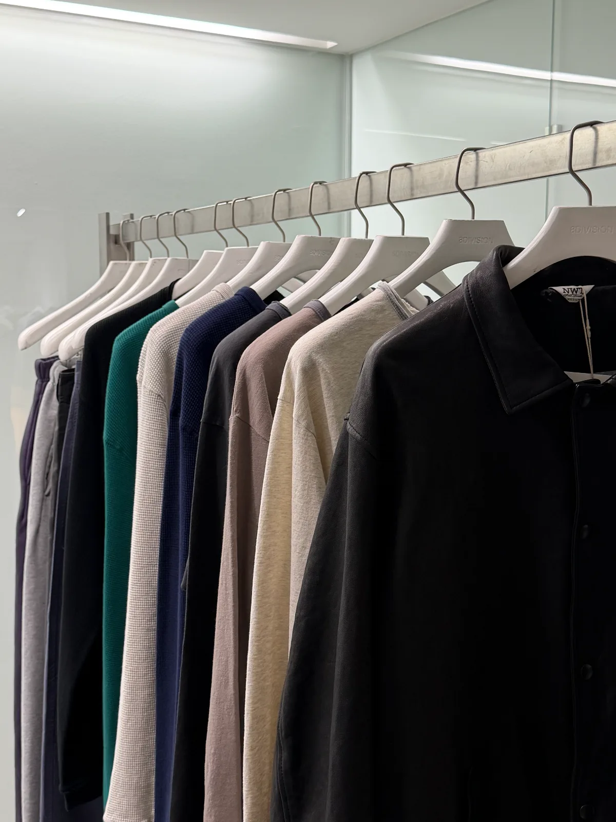 白いハンガーに並ぶ色とりどりの服
