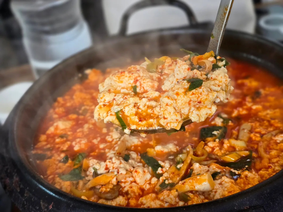湯気の立つ鍋からすくった豆腐