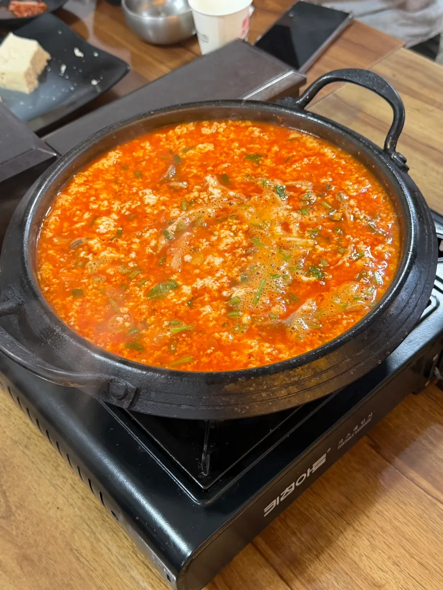 卓上コンロで煮立つ赤い豆腐鍋