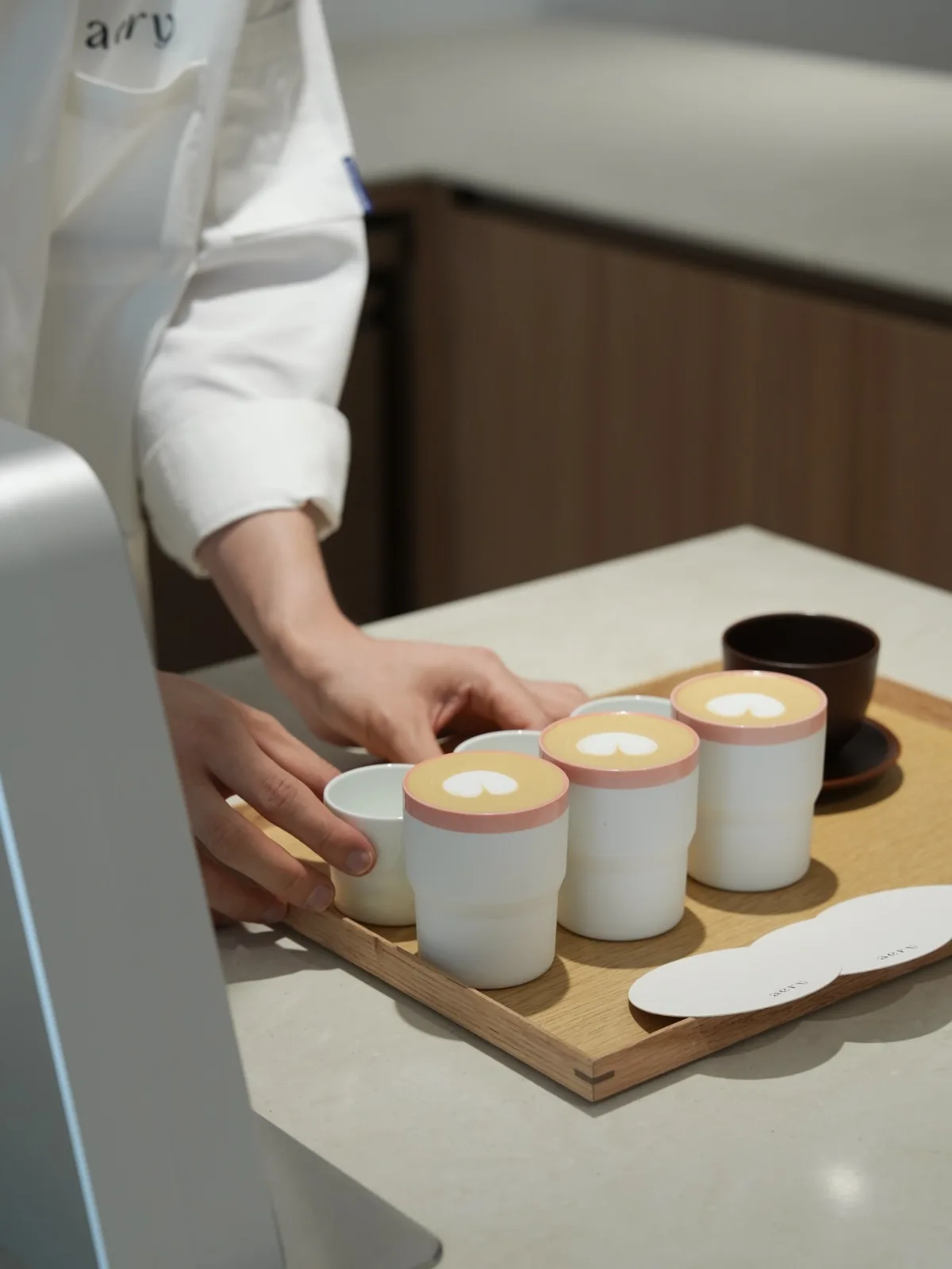 木のトレーに並ぶ三杯のラテ