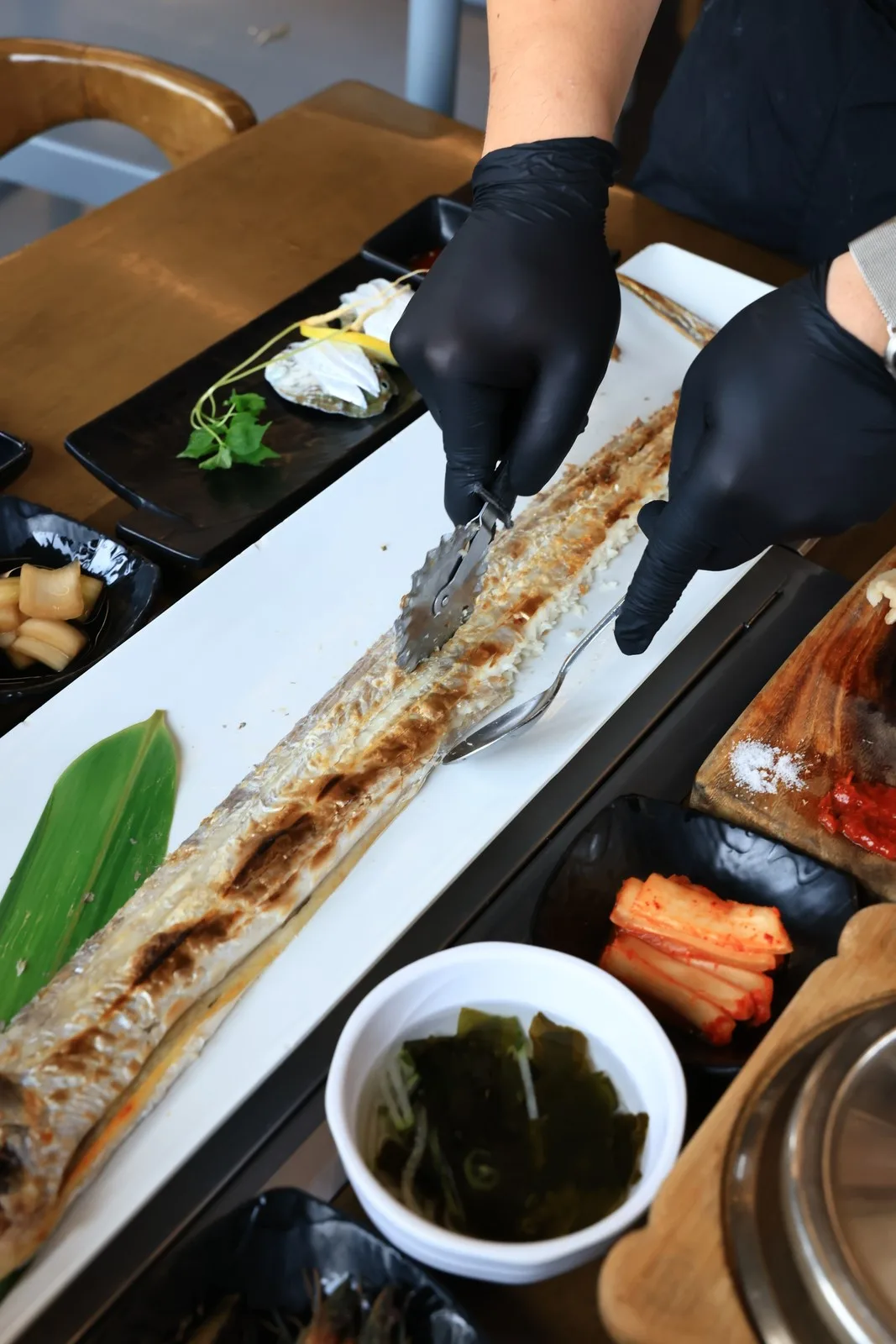 太刀魚の丸焼きの骨を外す手元