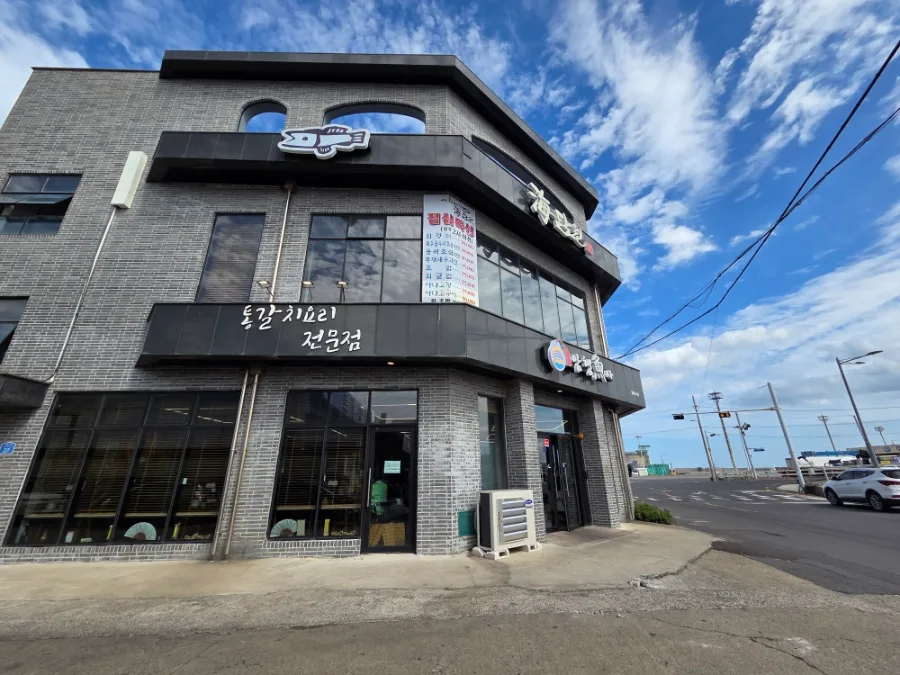 涯月カルチ・アムヘンオサ — 太刀魚料理の看板があるレンガ造りの店