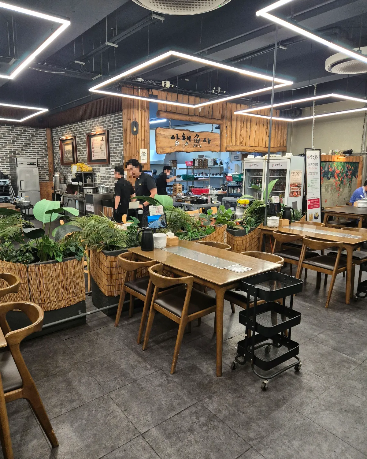 涯月カルチ・アムヘンオサ — 木のテーブルと植栽が並ぶ店内