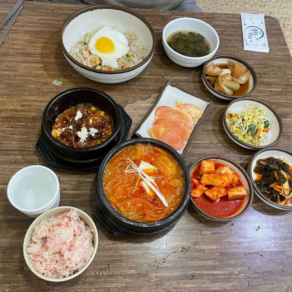 チゲとご飯、おかずが並ぶ食卓