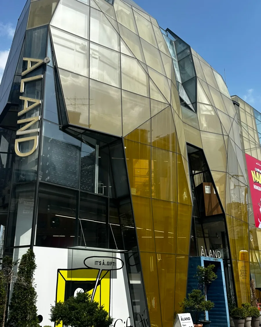 ALAND 弘大店 — 黄色いガラスと青い入口階段