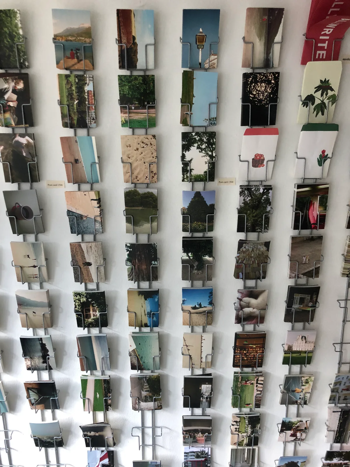 写真のポストカードが壁一面に並ぶ棚