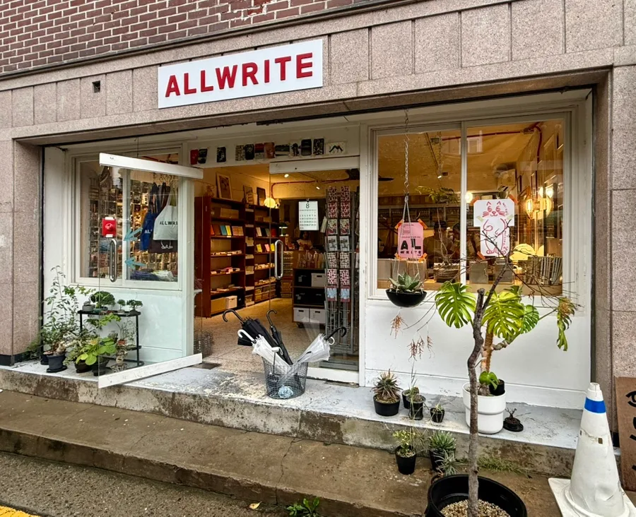 ALLWRITE 西村店 — 赤い店名看板と鉢植えの入口