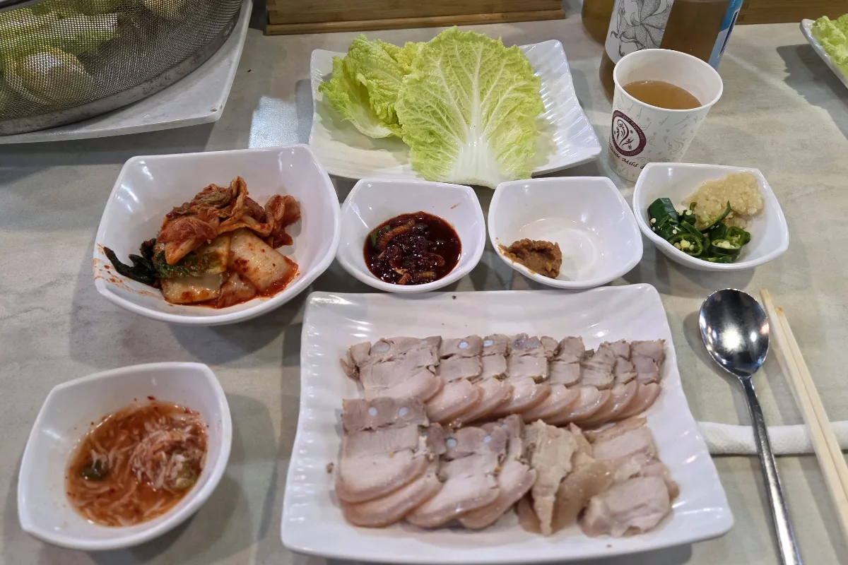 安東チッ — 茹で豚と白菜、薬味が並ぶ食卓