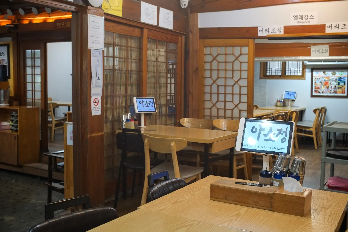 アソジョン — 木の格子戸とテーブル席