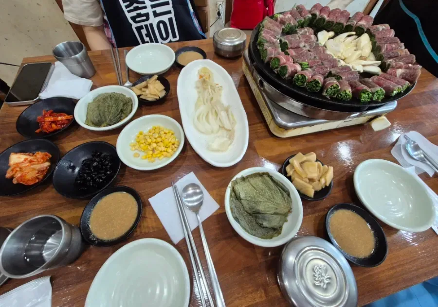 アスラ 本店 — コギマリと小皿料理が並ぶ食卓