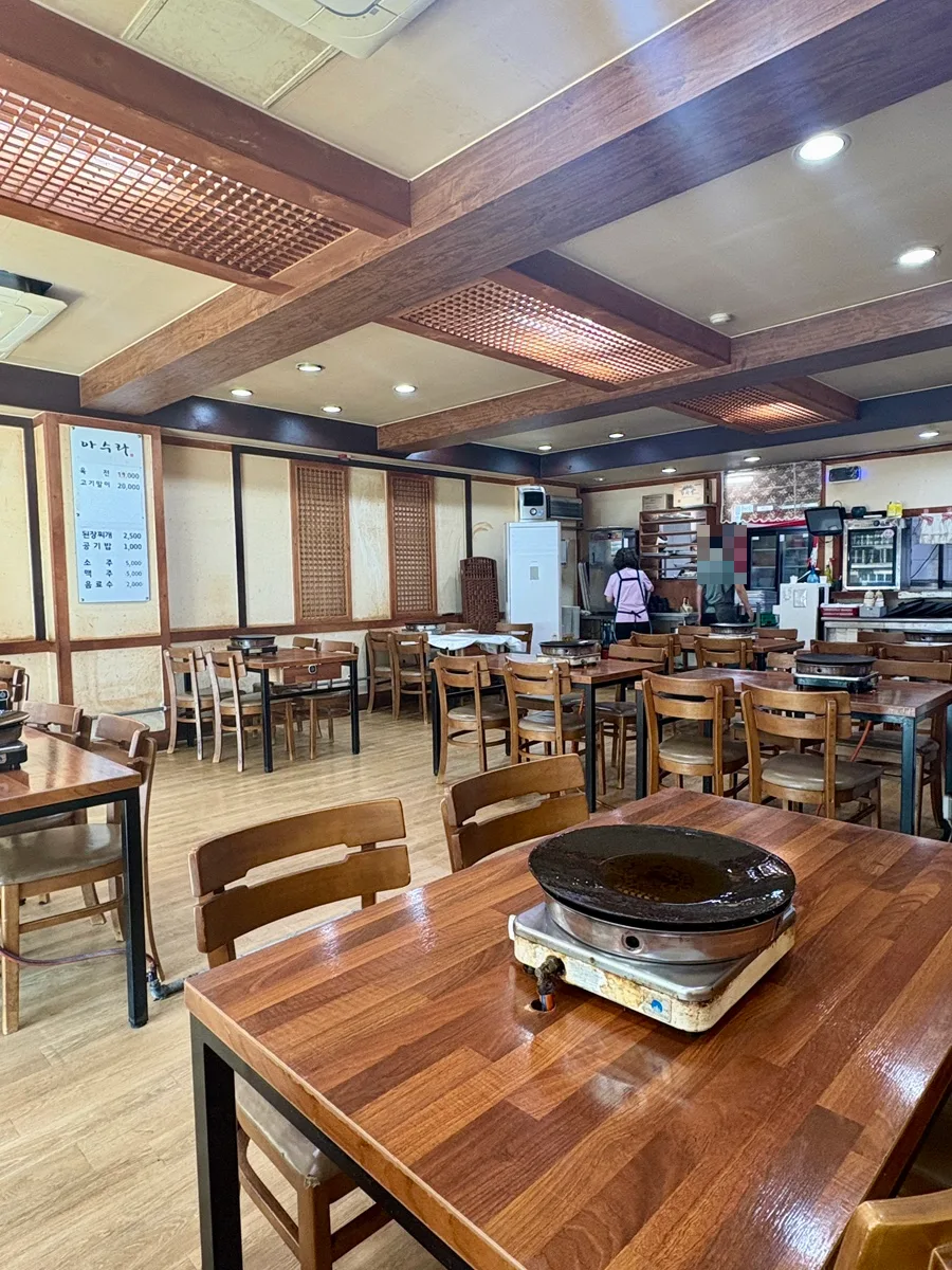 アスラ 本店 — 卓上コンロを置いた木のテーブル