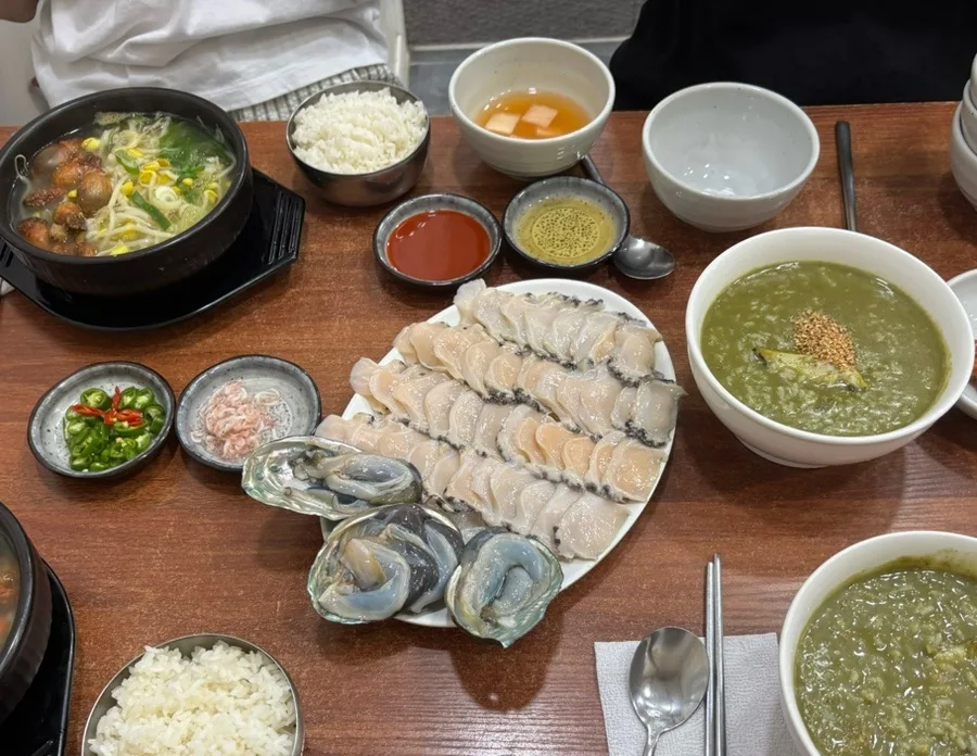 パダマル — アワビの刺身と粥が並ぶ食卓