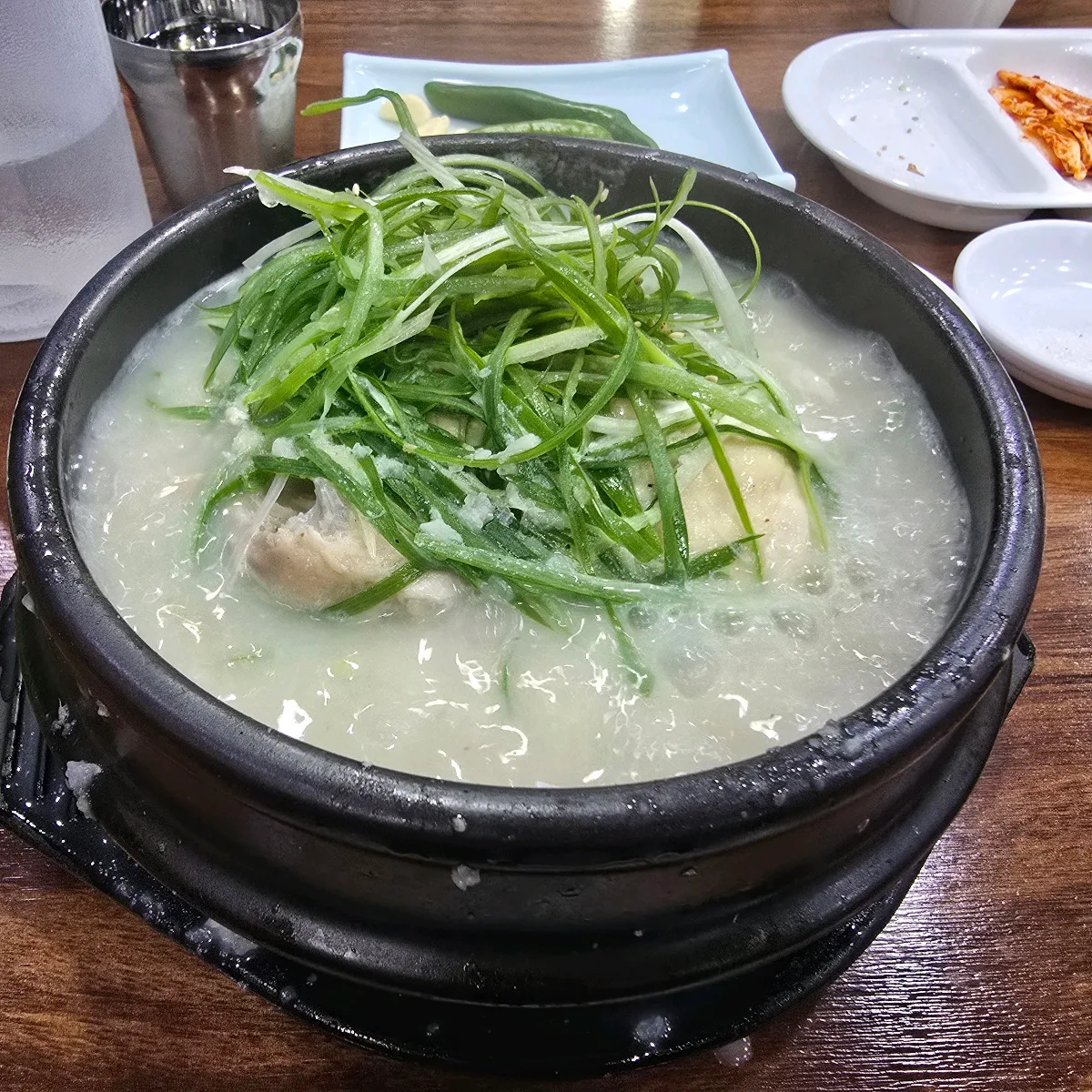 東莱参鶏湯 — 白いスープと山盛りのねぎ