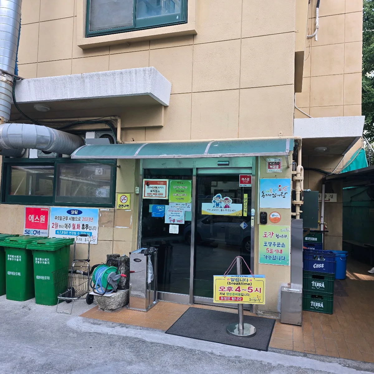 緑のひさしと営業案内がある入口