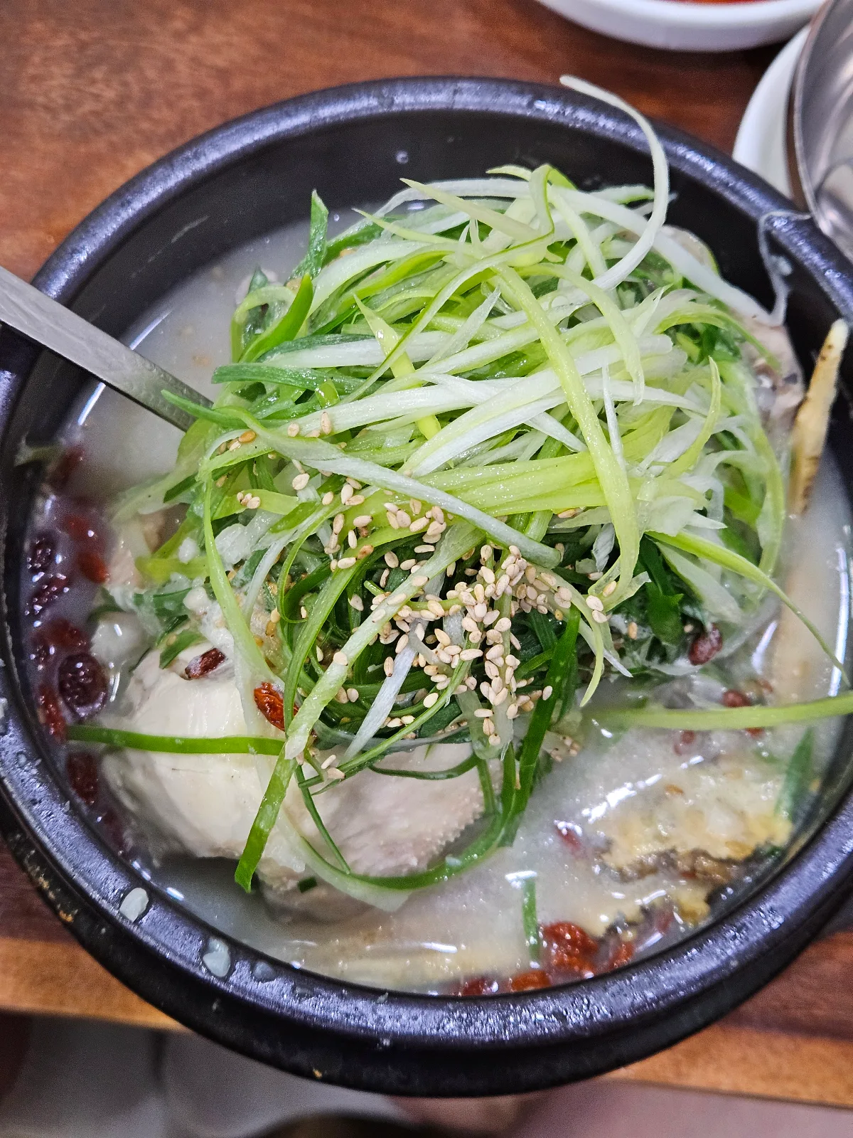 細切りねぎとごまをのせた参鶏湯