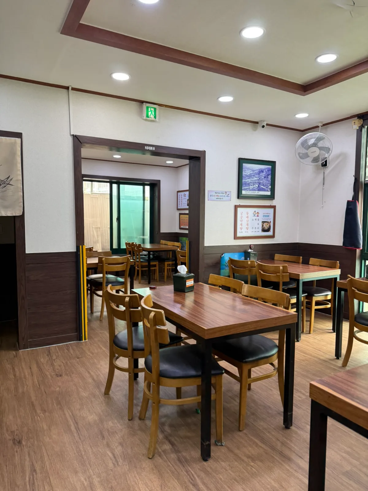 東莱参鶏湯 — 木のテーブルと椅子が並ぶ店内