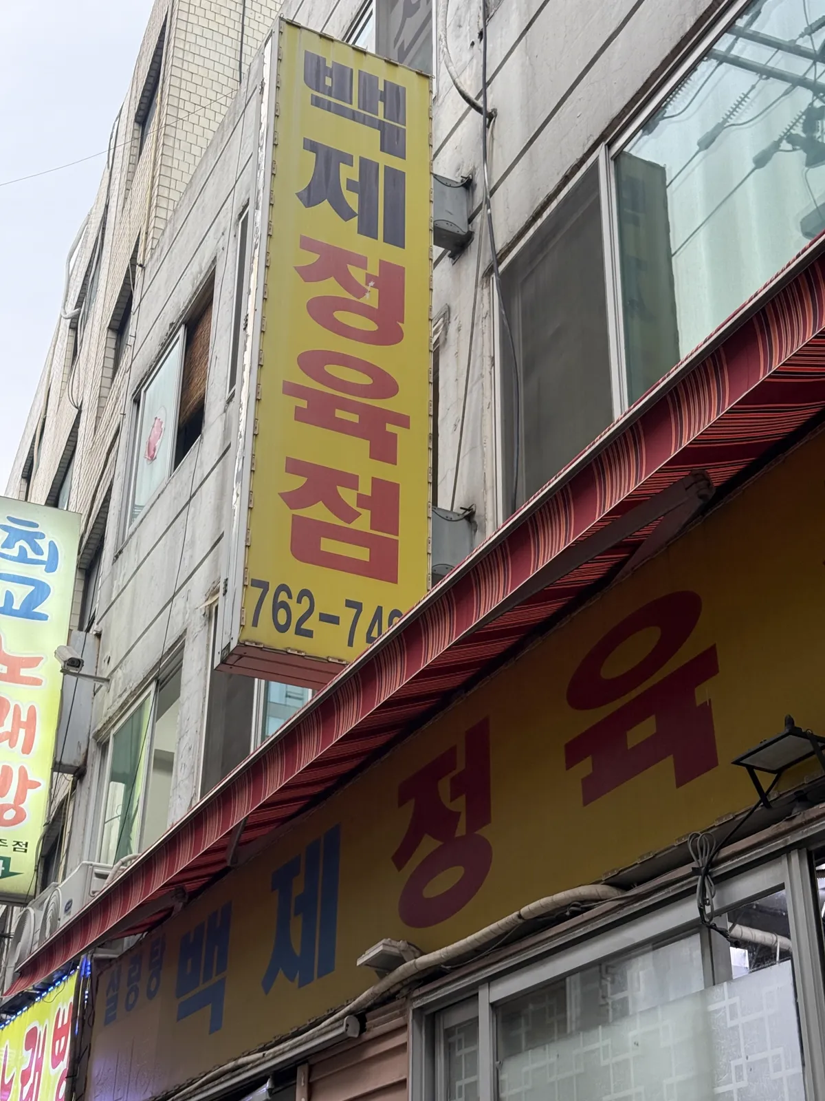 百済精肉店の黄色い看板
