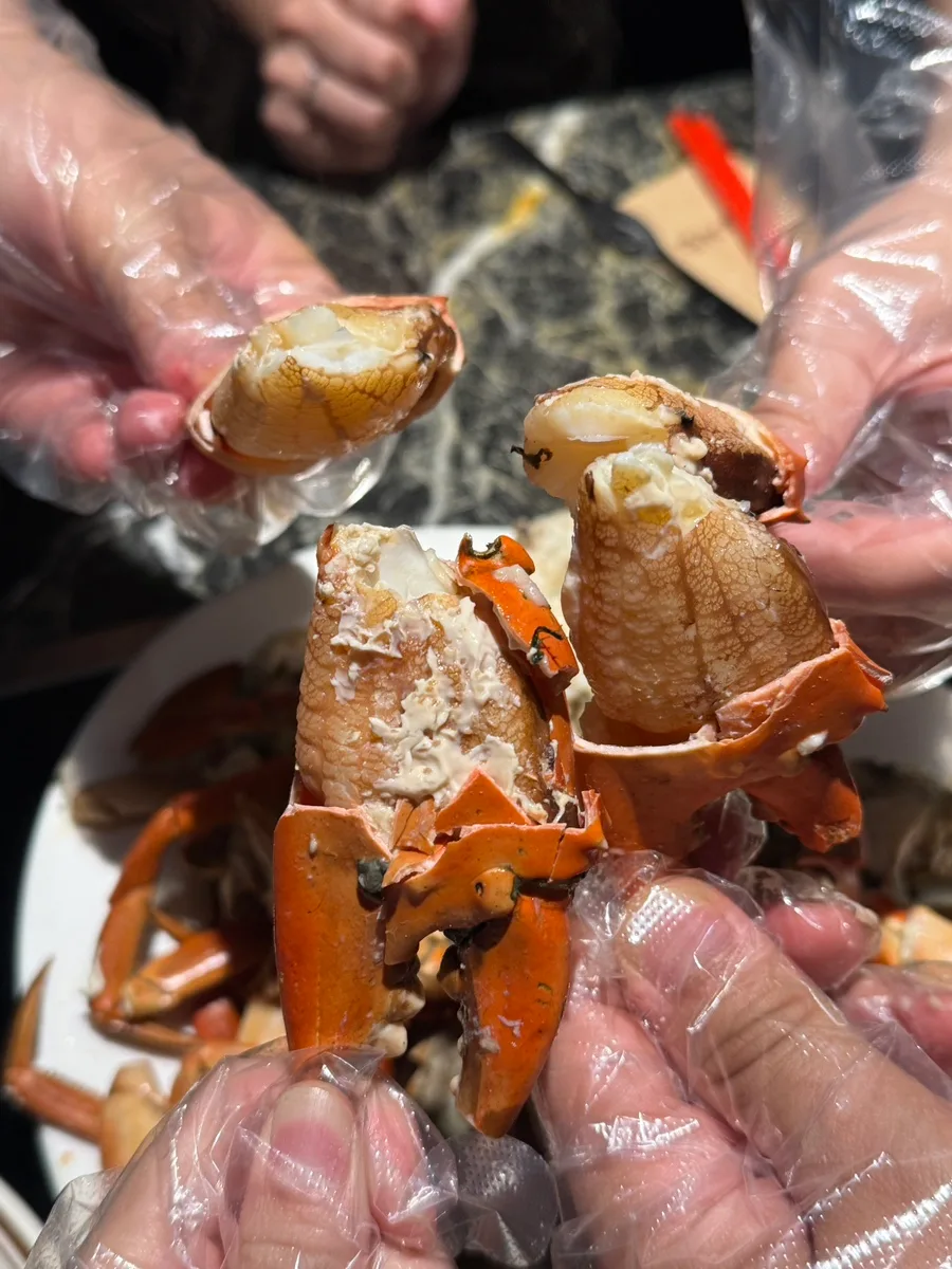 手袋をした手で殻を外したカニ