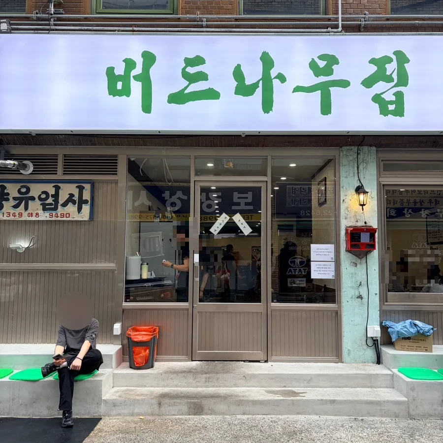 ポドゥナム・チプ — 白地に緑の文字の大きな看板がある店先