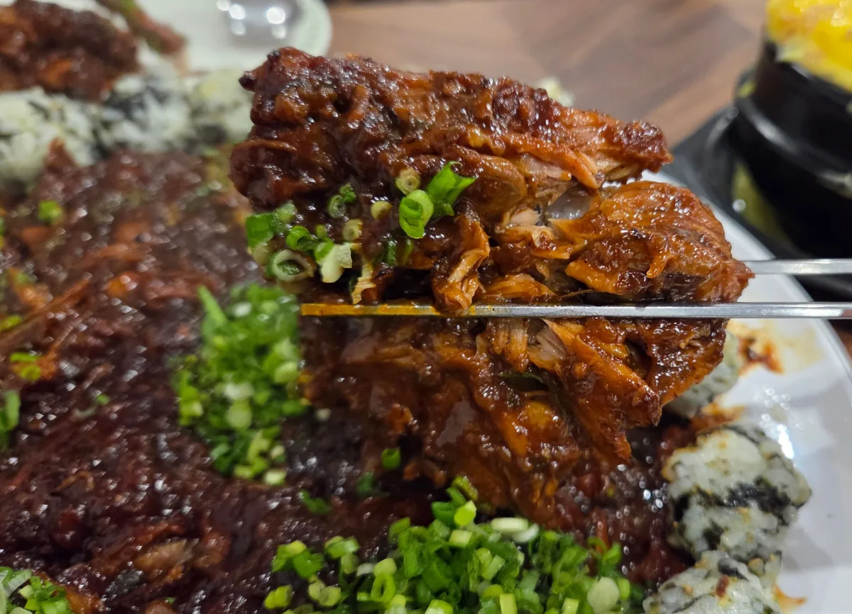 箸で持ち上げた骨付き肉