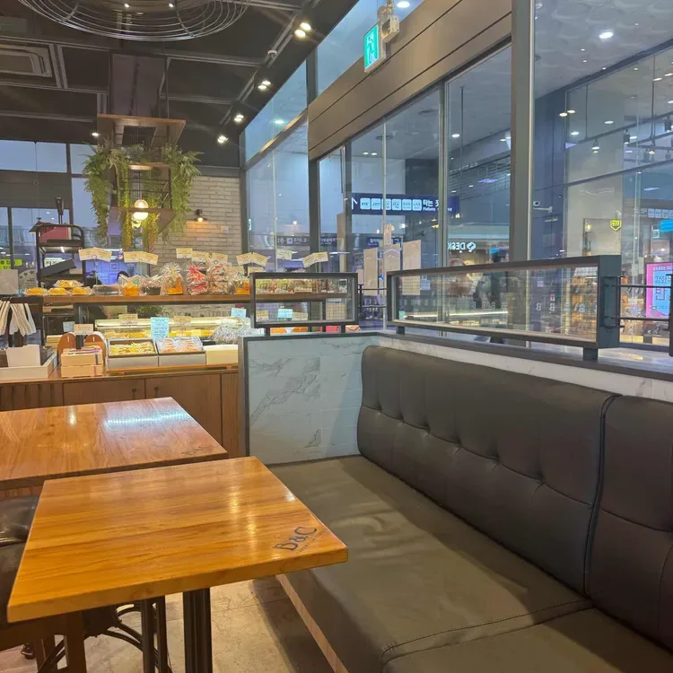 B&C製菓 釜山駅店 — 窓沿いのソファ席と木製テーブル
