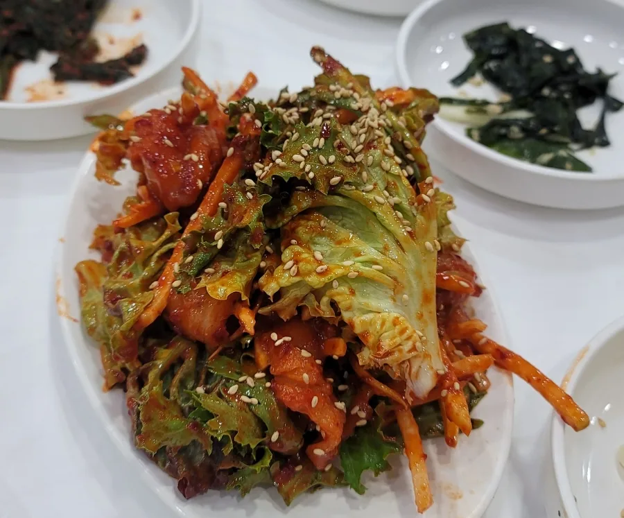 赤いたれで和えた魚と葉野菜