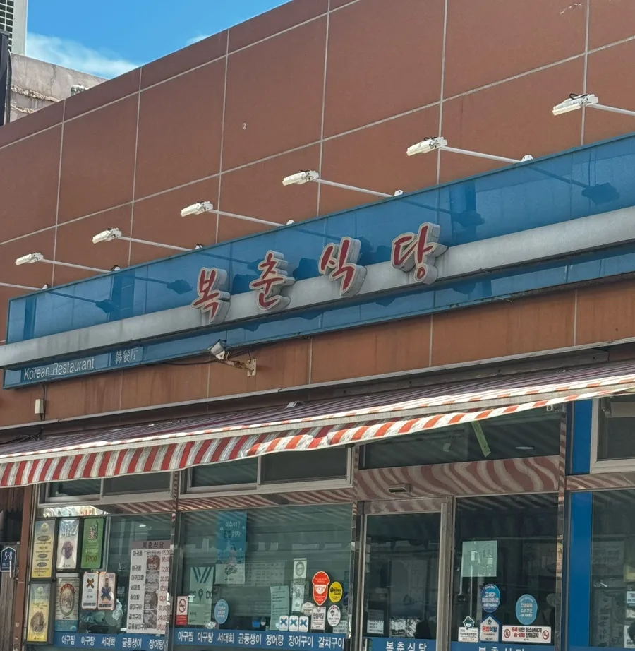 ポッチュン食堂 — 青い看板と縞模様のひさし