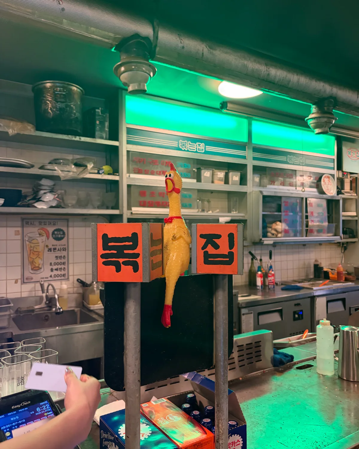 店名の看板とゴム製のニワトリが置かれた鉄板カウンター