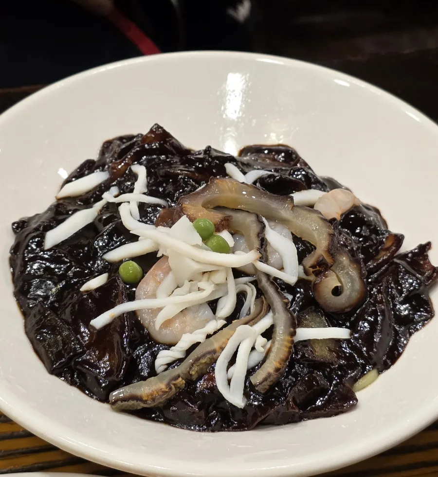 ナマコやエビがのった黒いソースの一皿