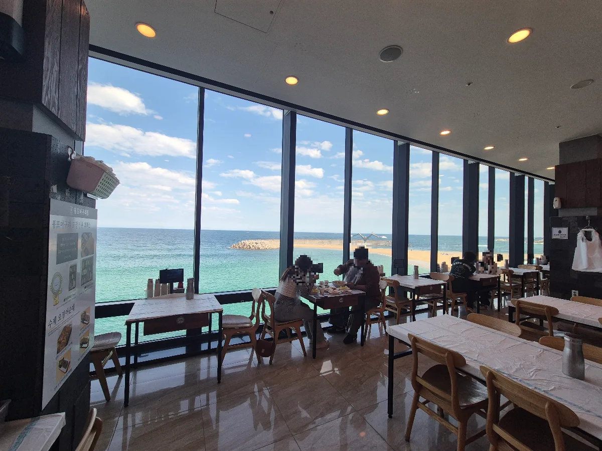 ボンポ・モグリチプ 本店 — 海を望む大きな窓とテーブル席
