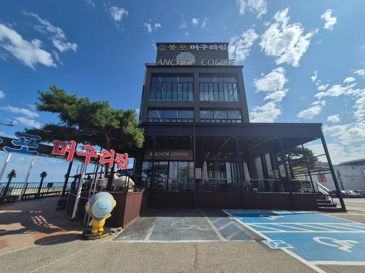 ボンポ・モグリチプ 本店 — 店名看板を掲げた建物と駐車場