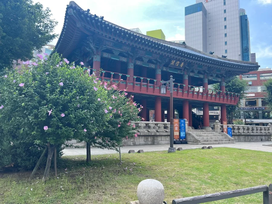 青空の下に立つ普信閣と鍾路のビル