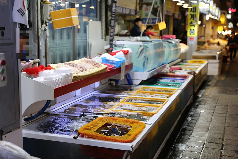 釜田市場 — 鮮魚店の前に連なる水槽