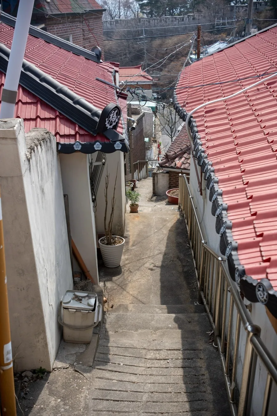 赤い屋根の間を下る細い階段