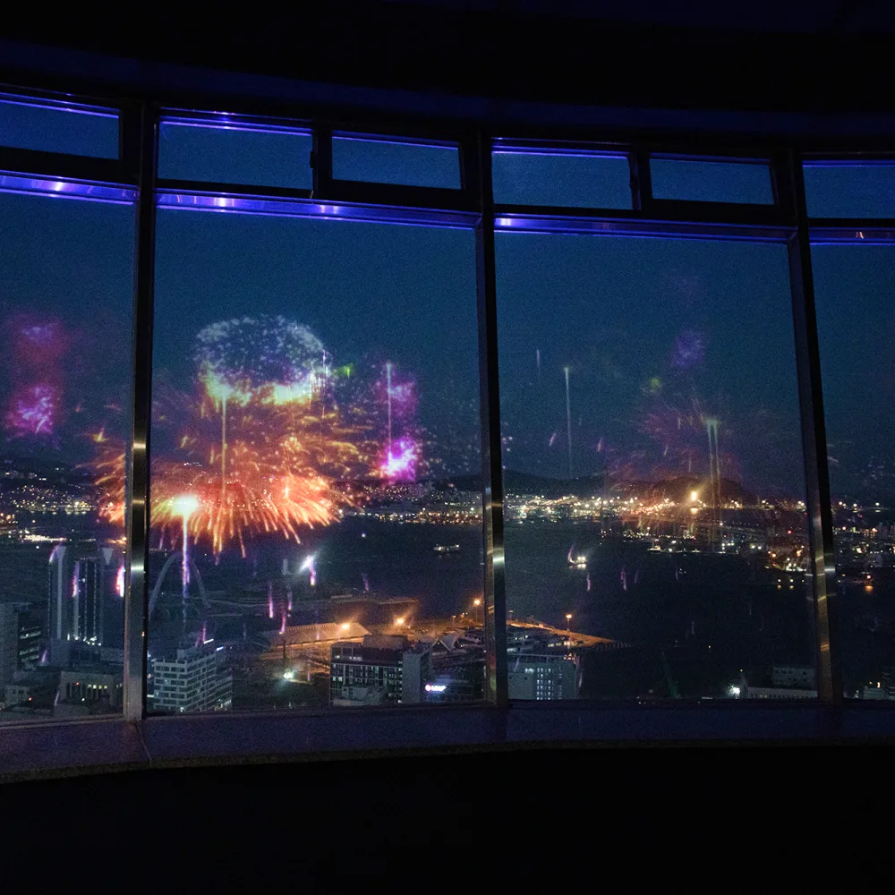 展望台の窓に映る花火と港の夜景