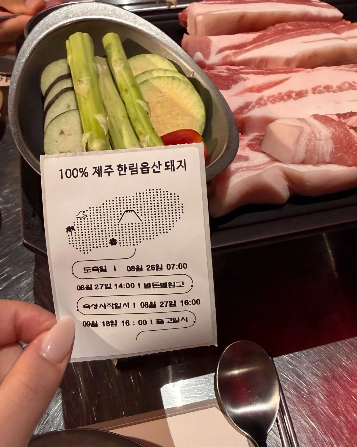 と畜日と熟成時間を記したカードと焼く前の豚肉