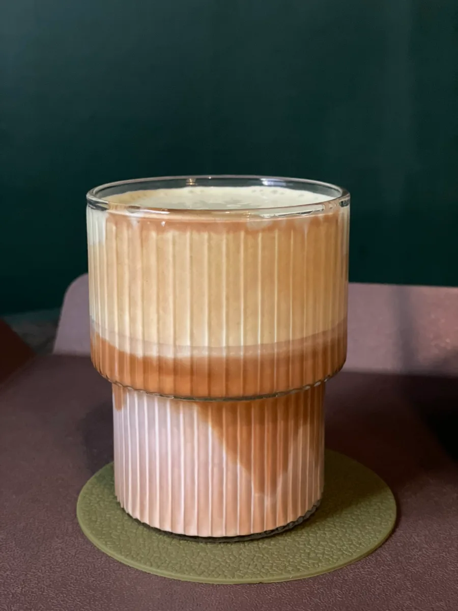 カフェ・モンジュン — しま模様のグラスに入ったカフェラテ