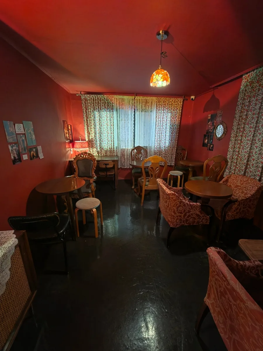 赤い壁の部屋に並ぶ木の椅子