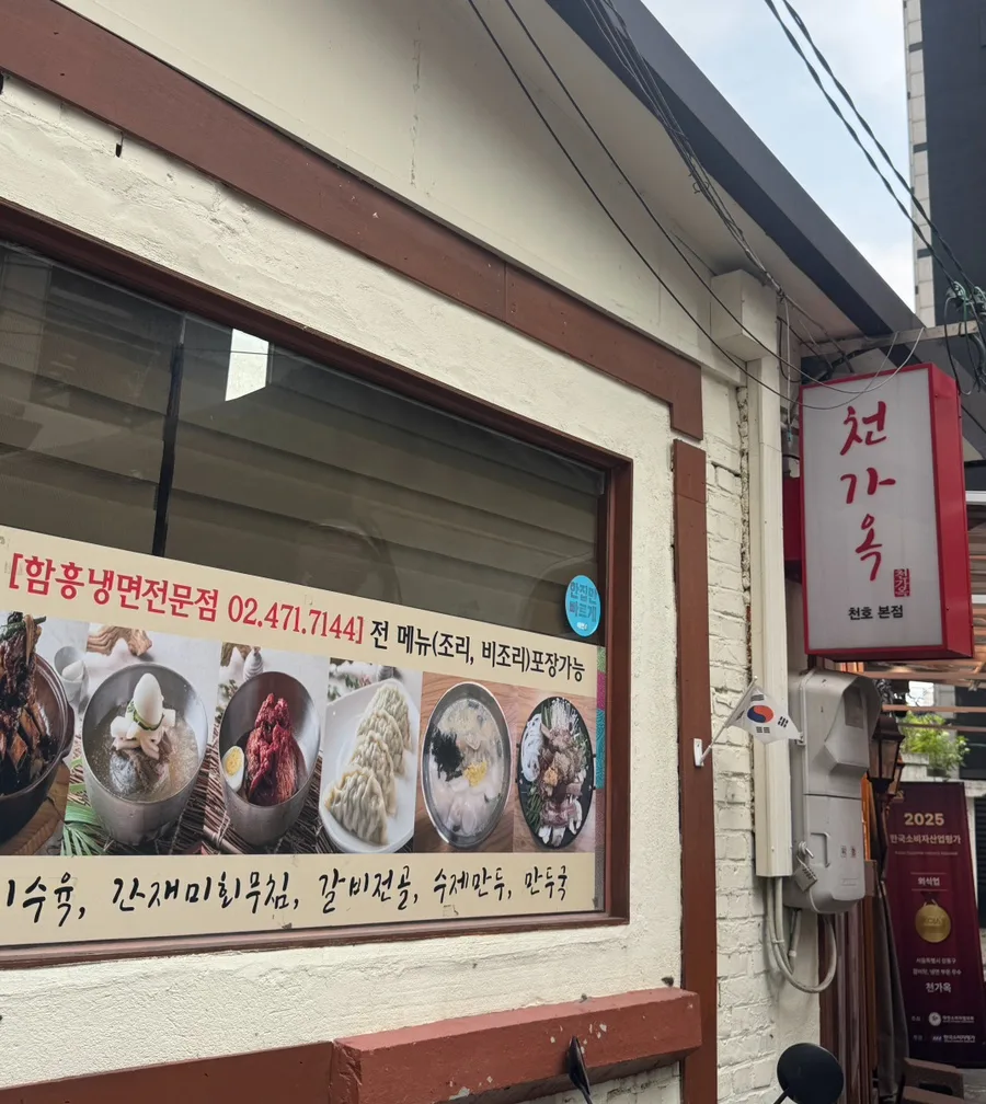 赤い看板とメニュー写真が並ぶ店の外観