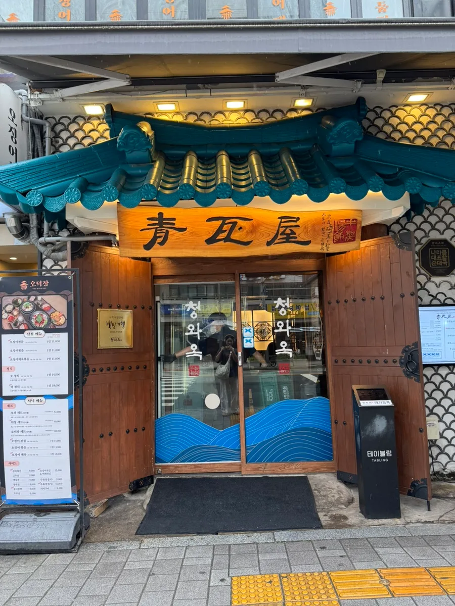 青瓦屋 乙支路3街店 — 青い瓦屋根と木製看板の入口