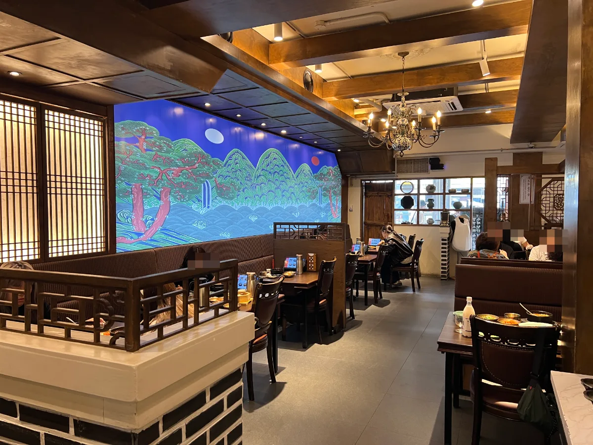 青瓦屋 乙支路3街店 — 木の梁と壁画がある客席