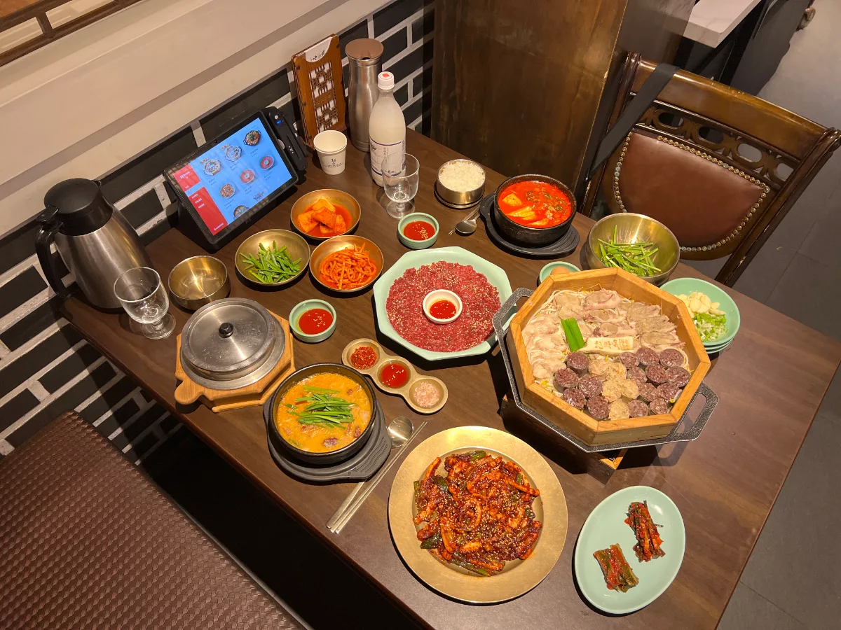 青瓦屋 乙支路3街店 — 蒸籠料理とスープが並ぶ食卓