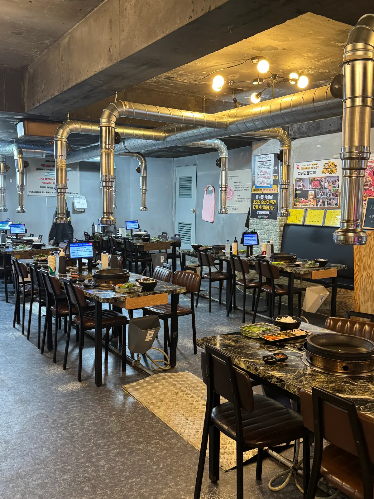 チコリ・セングイ 束草店 — 排煙ダクトが並ぶ焼肉席
