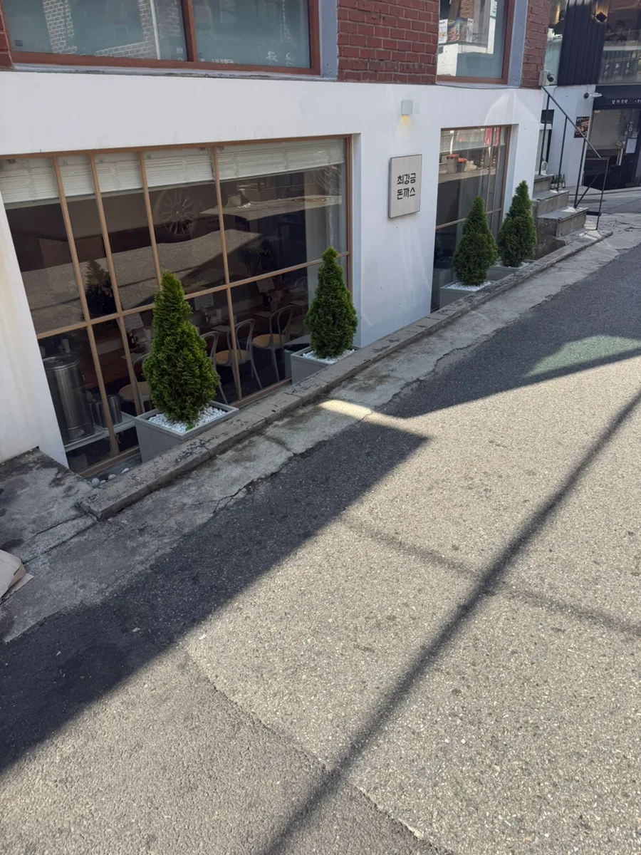 白い外壁に小さな看板が出た半地下の店先