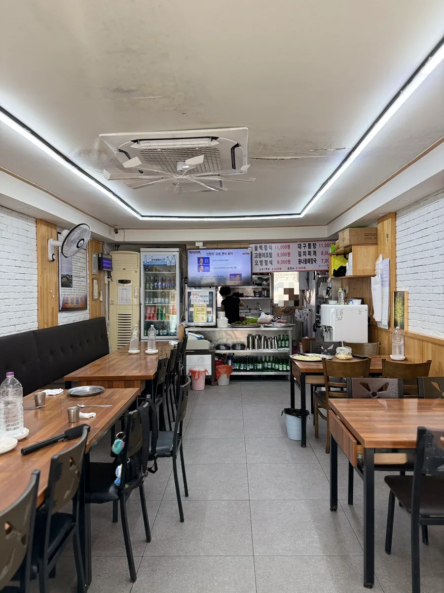 草梁プルベッ — 木のテーブルが並ぶ細長い店内