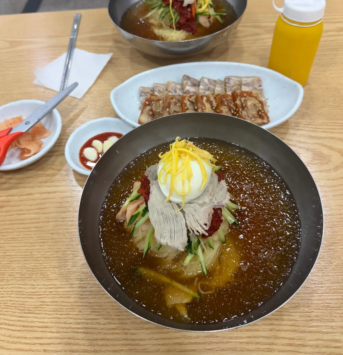 春夏秋冬ミルミョン 西面本店 — 冷たい麺と薄切り肉が並ぶ食卓