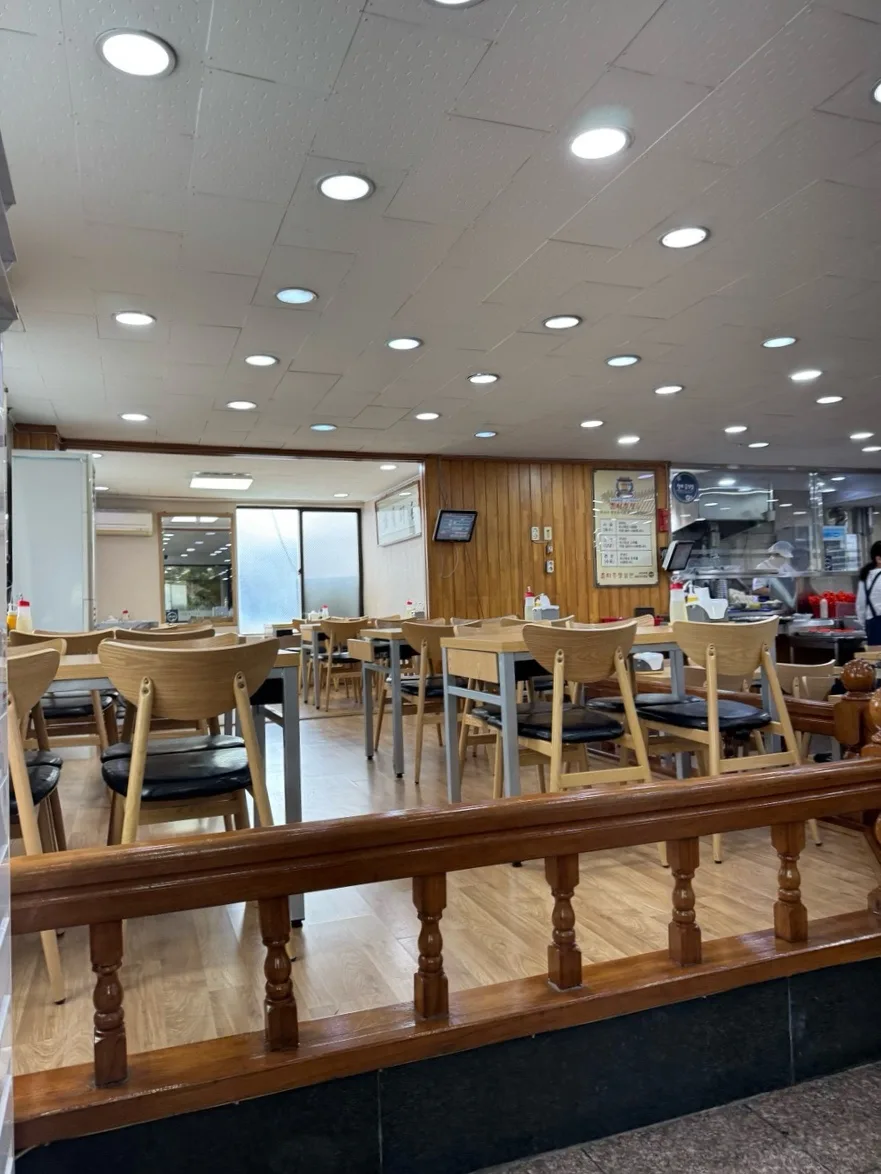 春夏秋冬ミルミョン 西面本店 — 木のテーブルと椅子が並ぶ店内
